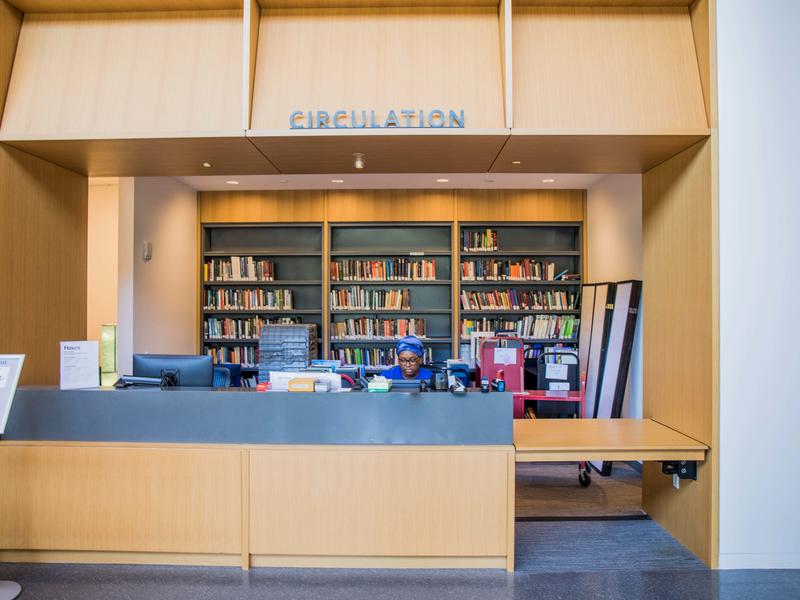 Big view of the circulation desk, with a student worker