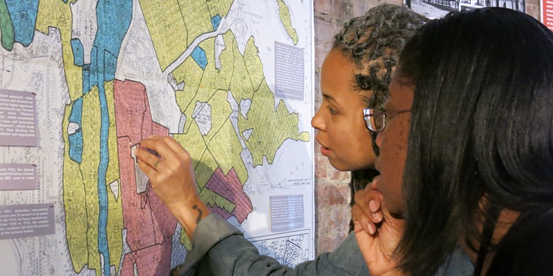 Two young black women placing a pin on a colorful map