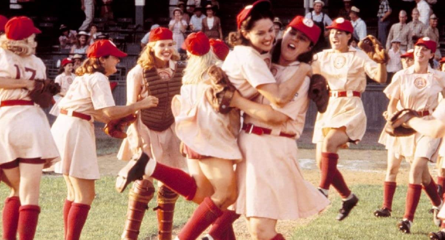 A photo of a group of women dressed in baseball uniforms celebrating their performance in a baseball game