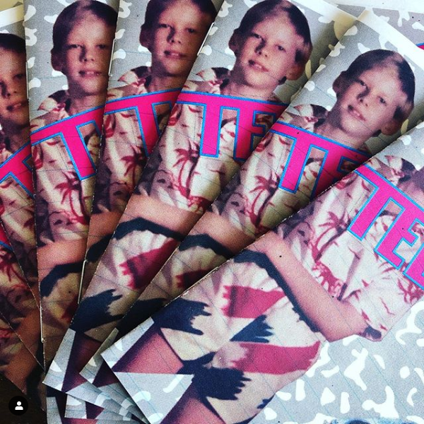 photo of spread of zine covers, white presenting male presenting child in 1980s style shorst and tucked in shirt