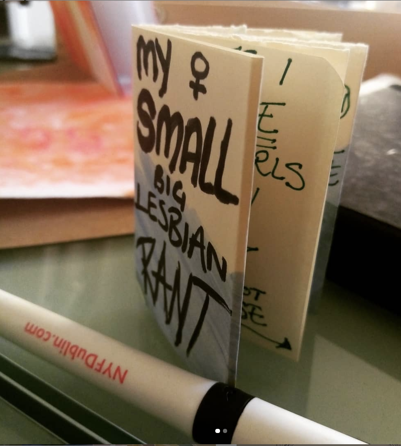 photo of My Small Big Lesbian Rant zine, which is tiny (about 7cm tall), next to a pen for scale. 
