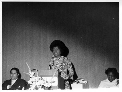 A woman speaking at a podium. Image from The quest for labor equality in household work: National Domestic Workers Union, 1965-1979