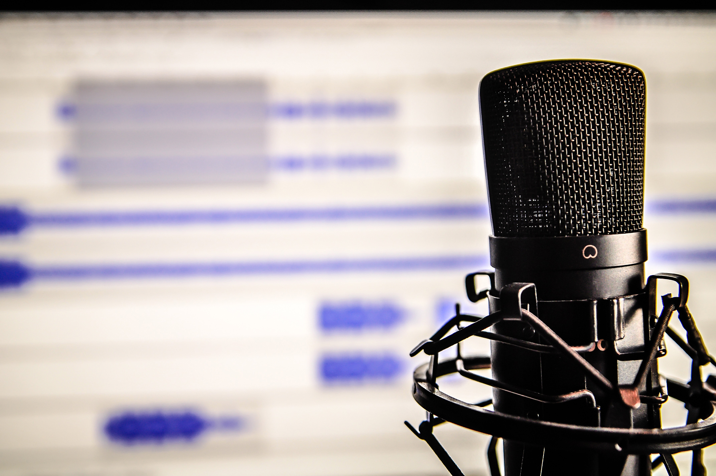 Microphone in front of audio editing software on a screen