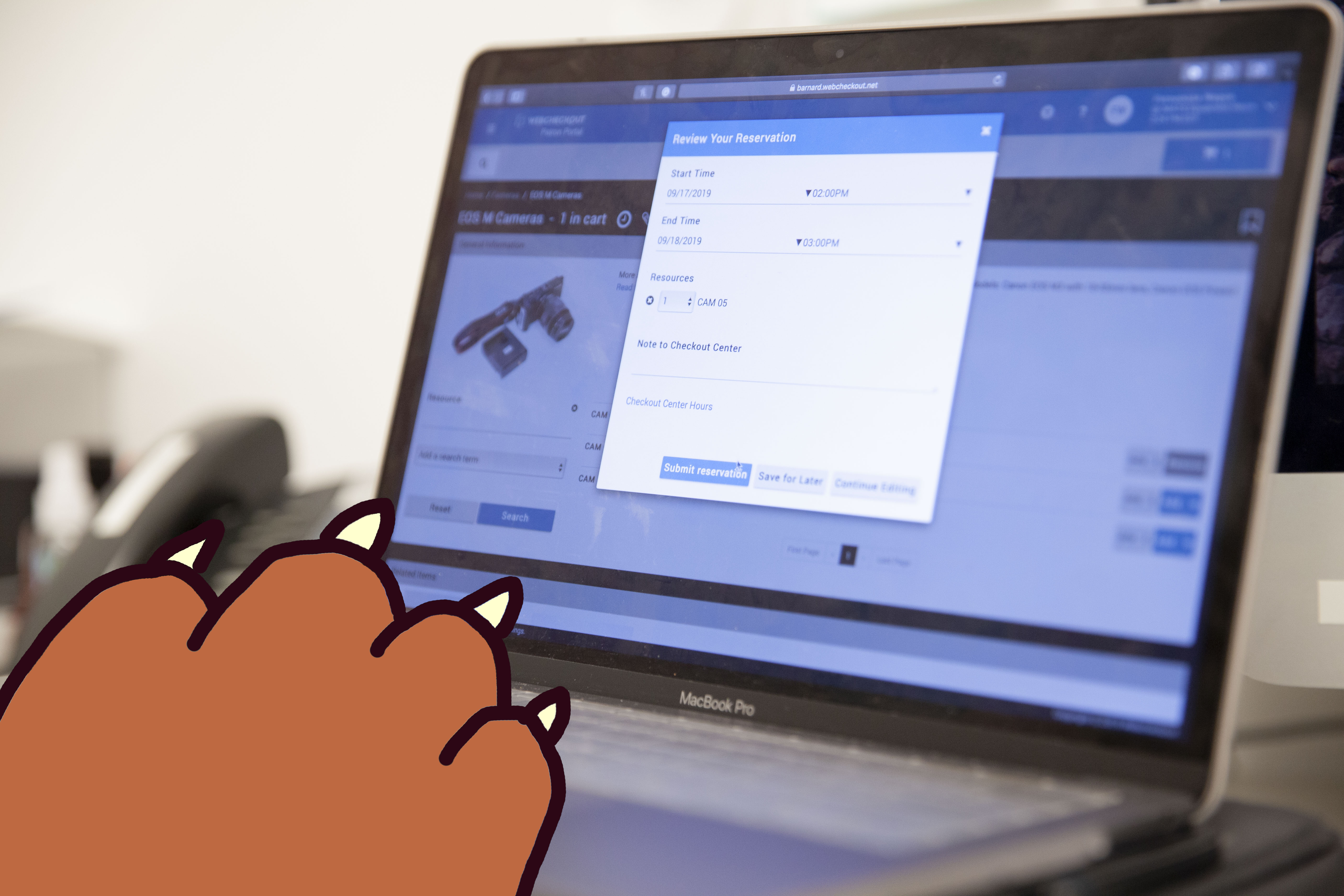 A bear paw accessing the IMATS Patron Portal on a computer.