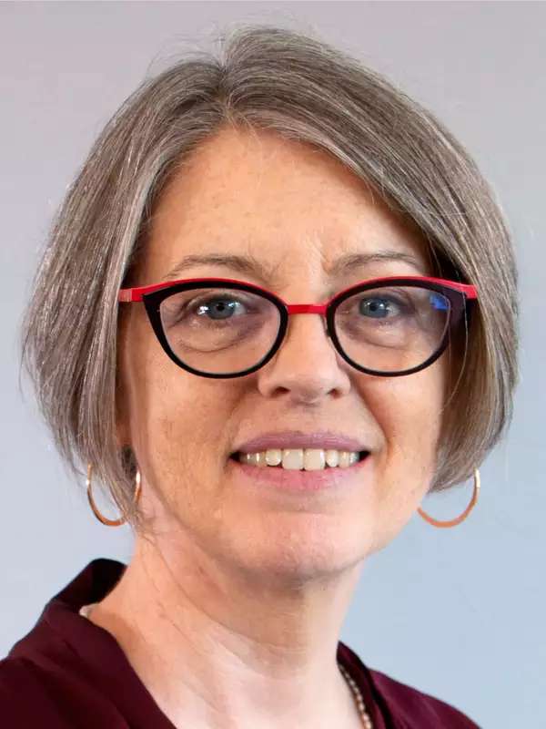 woman with short gray hair and glasses