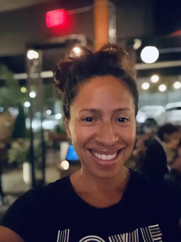 Woman with a big smile and brown hair worn up