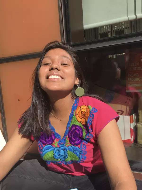 Woman with long hair smiling outside the Diana Center