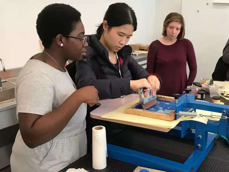 Students creating a print in the Design Center